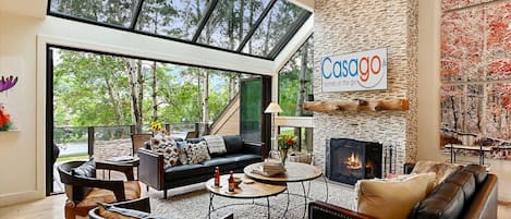 Living area boasts floor-to-ceiling windows, offering breathtaking natural light and lush outdoor views.