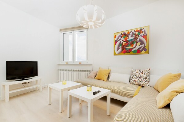 The living room features a sleek coffee tables and a flat-screen television.