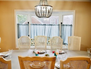 French style vintage dining table and chairs with bay windows for natural light.

