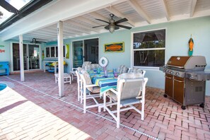 Covered patio with seating, BBQ, cooler,