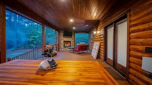 Covered Deck with Fireplace, Table, TV, and Furniture