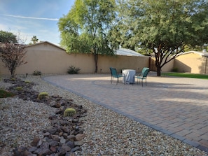 Relaxing backyard with a firepit, covered patio and a ping pong table.