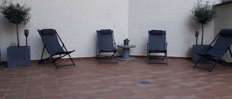 Zona de estar de la terraza, con olivos y luz solar para noches de relax