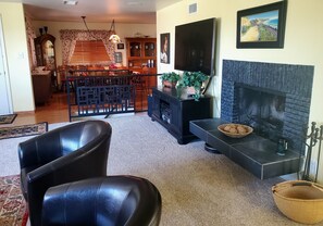 Living room view showing 65" Roku TV and wood burning fireplace 