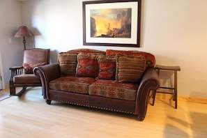 Custom leather/down couch; hand carved rocking chair; copper shade lamp