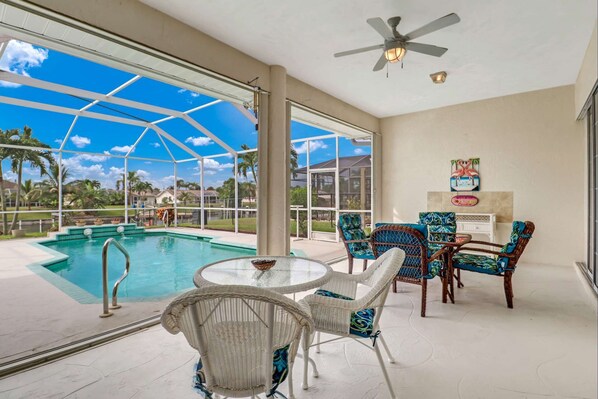 Enjoy your meals or morning coffee overlooking the pool and canal under the covered portion of the screened lanai.