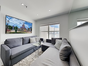 Relax in this comfy living room with sofa bed option plus 70-inch Smart TV.