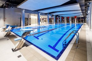 A luxurious indoor swimming pool with lanes for exercise and a relaxing environment.