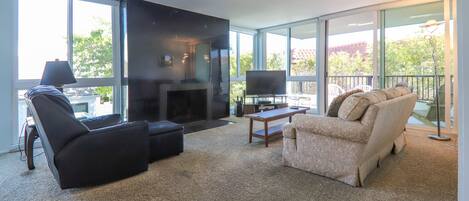 Living room with floor to ceiling windows - Comfortable living room with tons of light and patio.