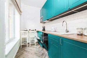 Kitchen with fridge, dishwasher, kettle, stove, sink, coffee maker, microwave, cupboards and dining area