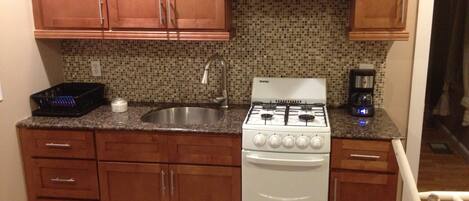 Kitchen with new cabinets, granite counter, glass backsplash