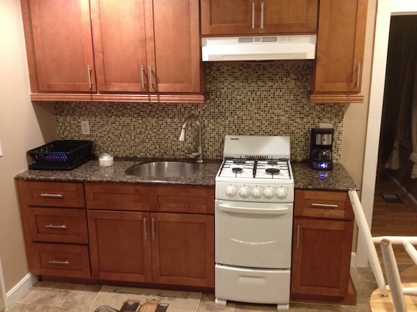 Kitchen with new cabinets, granite counter, glass backsplash