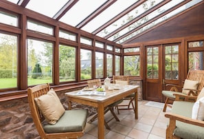 Ground floor: South facing conservatory with table seating six guests and doors to the garden