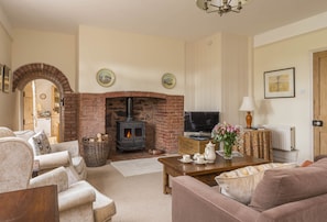 Ground floor: Spacious sitting room with feature fireplace and wood burning stove