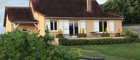 la maison, sa terrasse et un bout du jardin face au canal