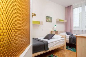 Stylish retro bedroom with two single beds and shelves and a chest of drawers.