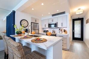 Fully stocked gourmet kitchen with quartz countertops.