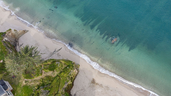 The turquoise ocean & beach below the beach house beckons walkers and explorers.