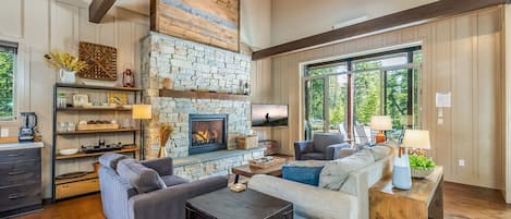 High ceiling great room with high definition Smart TV and indoor Fire Place