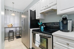 The fully stocked and functional kitchen features stainless steel appliances, a pantry, and it opens directly to the breakfast/bar/office nook.