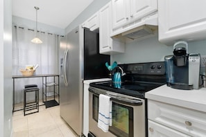 The fully stocked and functional kitchen features stainless steel appliances, a pantry, and it opens directly to the breakfast/bar/office nook.