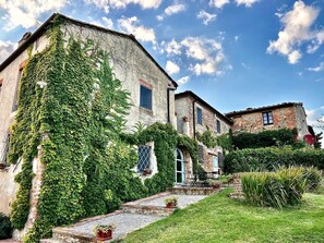 A beautiful view of the house and its old well by day