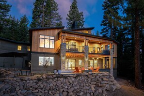 The back of the house showcase the two covered decks with stone and cedar siding