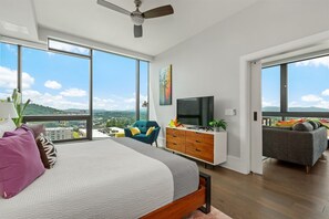 bedroom with king bed, side chair and 55 inch TV