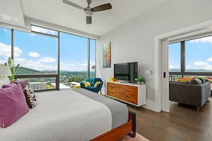 bedroom with king bed, side chair and 55 inch TV