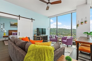 Living room with sleeper sofa, 55 inch TV and additional work space
