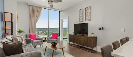 Living room with 55 inch TV, sleeper sofa, additional seating and slider window