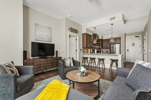 Living room overlooking into the kitchen with a breakfast bar seating 4