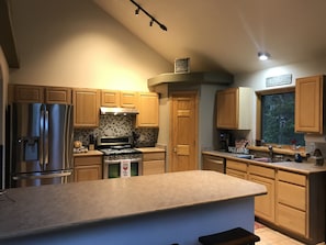 Large, fully stocked kitchen with breakfast bar.  