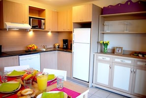 Prepare meals in the kitchenette and enjoy them at the dining table.