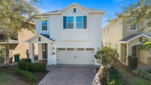Elegant two-story vacation home with spacious driveway and welcoming entrance.