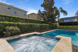 Relax in our private outdoor pool with jacuzzi, surrounded by lush privacy hedges—perfect for sunny afternoons.