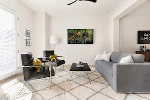 Mid-century modern furnishings and an enormous 70-inch TV in the living room (couch also opens to a queen-size sofa bed)