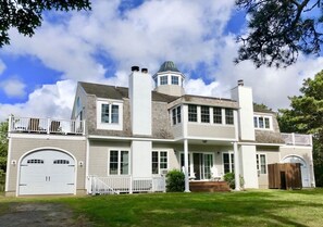 Rear of house overlooking large backyard, and expansive forest beyond.