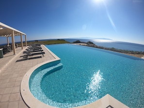 Large heated infinity pool 17m x 7m, 0.9m to 1.8m deep, with integrated jacuzzi