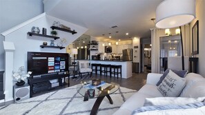 Living room features a 55" 4K smart TV. Stairs lead to loft above.