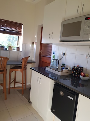 Kitchenette with a microwave, kettle and fridge.