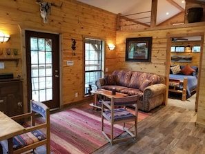 Living Room, Bedroom Entry and Sleeper Sofa with View of Porch and Hill Country.