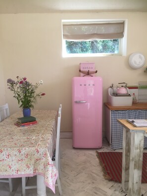 Open plan Kitchen, with double oven, pink fridge, washing machine, dishwasher...