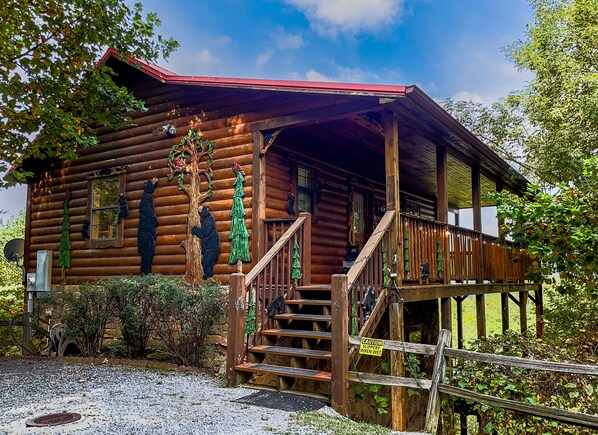 Cute storybook log cabin adorned with delightful bear and tree carvings