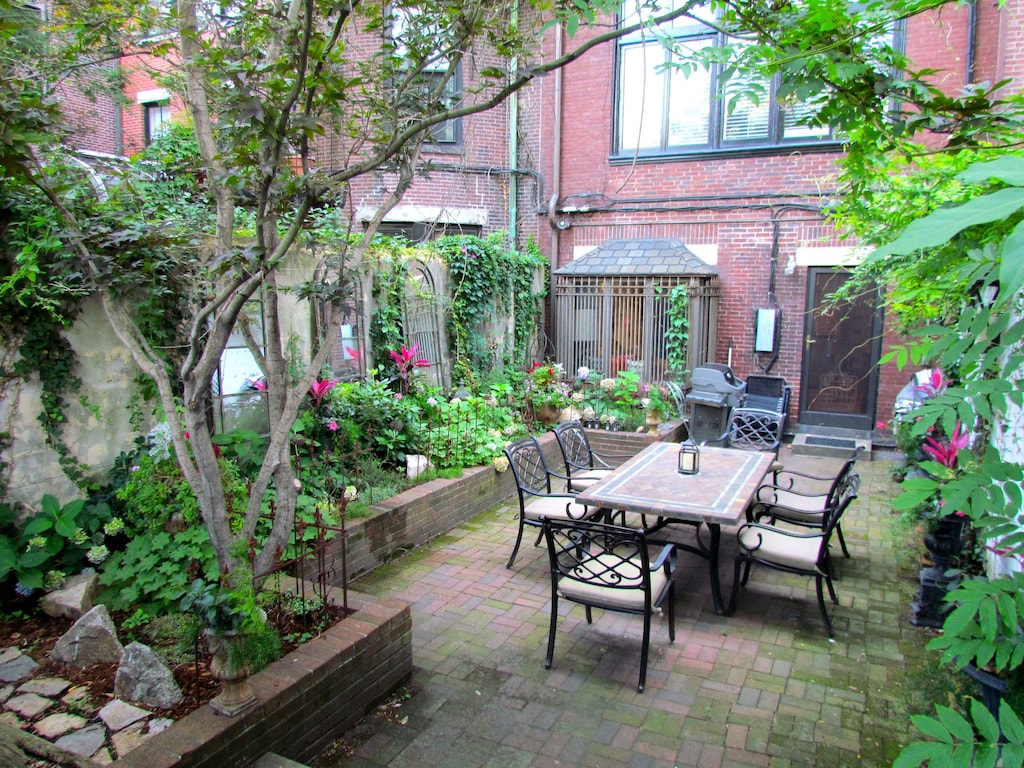 Private landscaped patio with dining table, bistro table and grill at a vacation rental