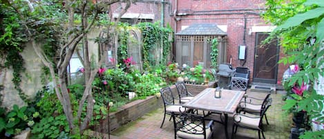 Private landscaped patio with dining table, bistro table and grill