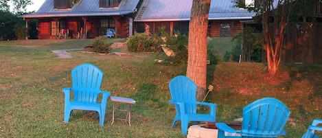 Sunrise view of fire pit and home from near the water