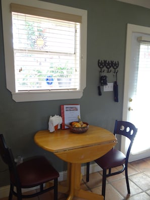 Intimate dining area with cushioned chairs and window for natural light.