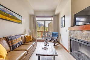 Comfortable living room with electric fireplace and walk out to the deck with magnificent mountain views