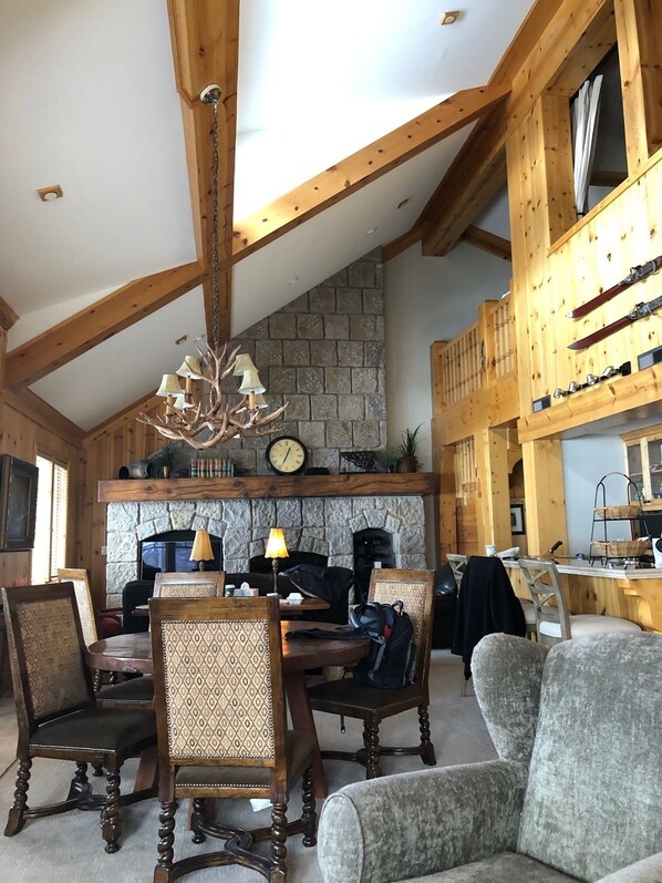 View from living room towards dining area, kitchen, stone fireplace and TV.